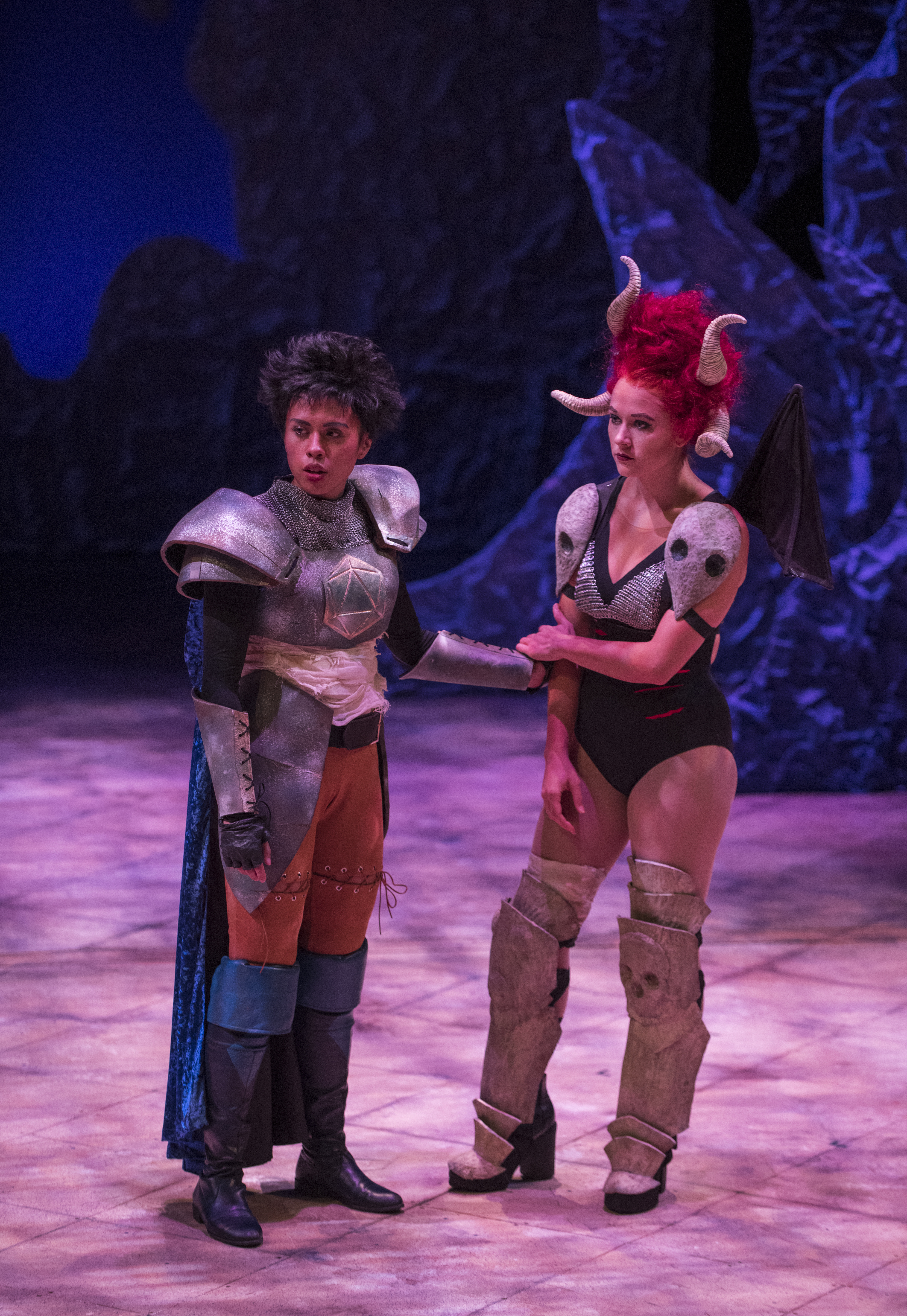 Production photo of two actors in costume, one in armor and one with a horned wig, from a production of She Kills Monsters